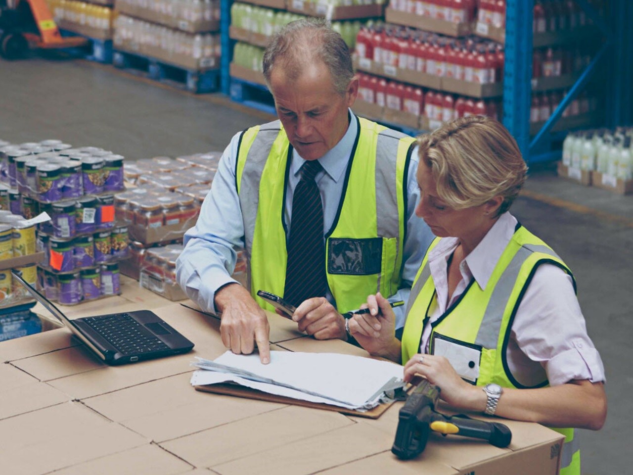 Male and a female with protective vests in a warehouse