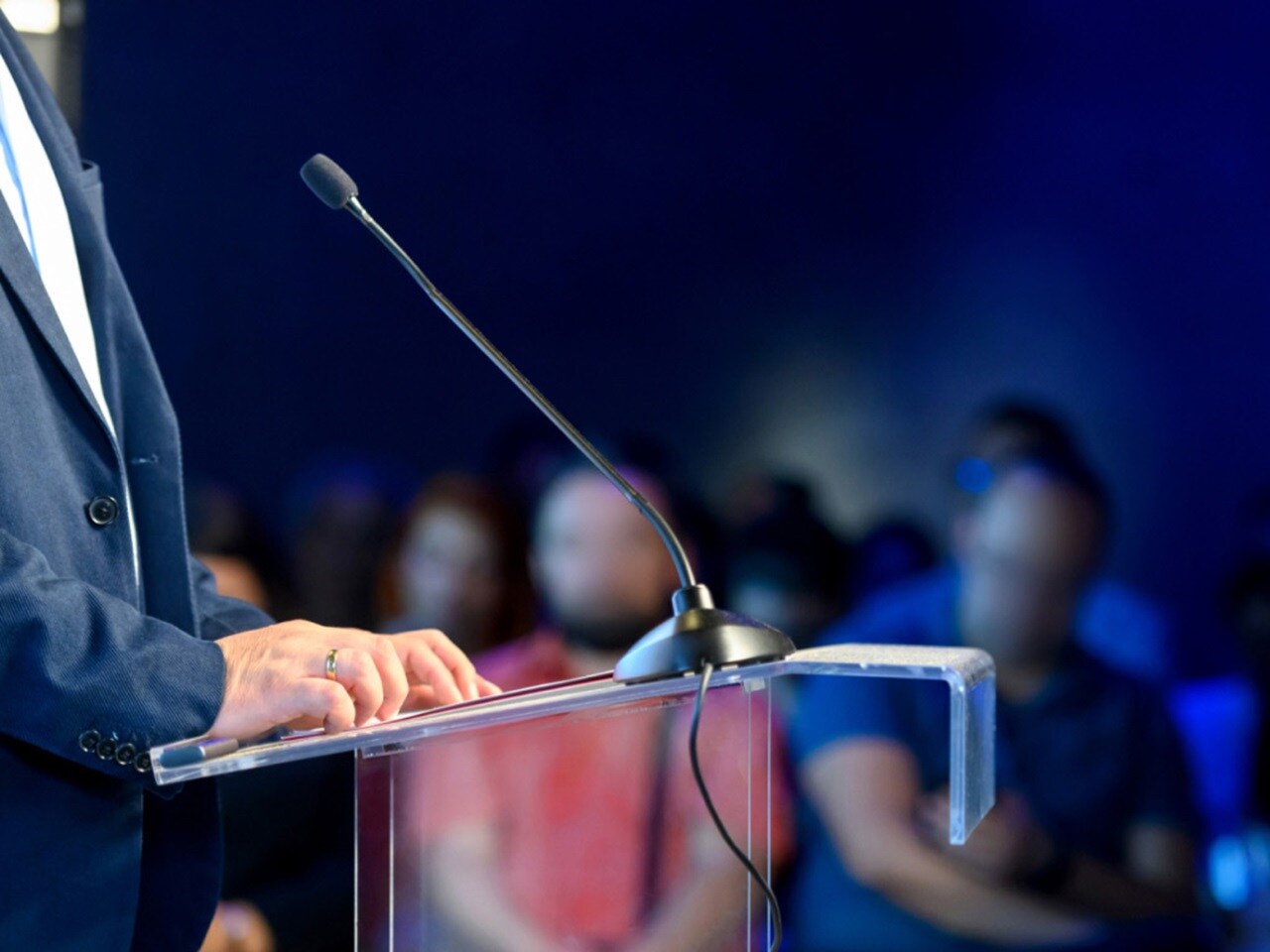 Palestrante em pé em pódio com microfone