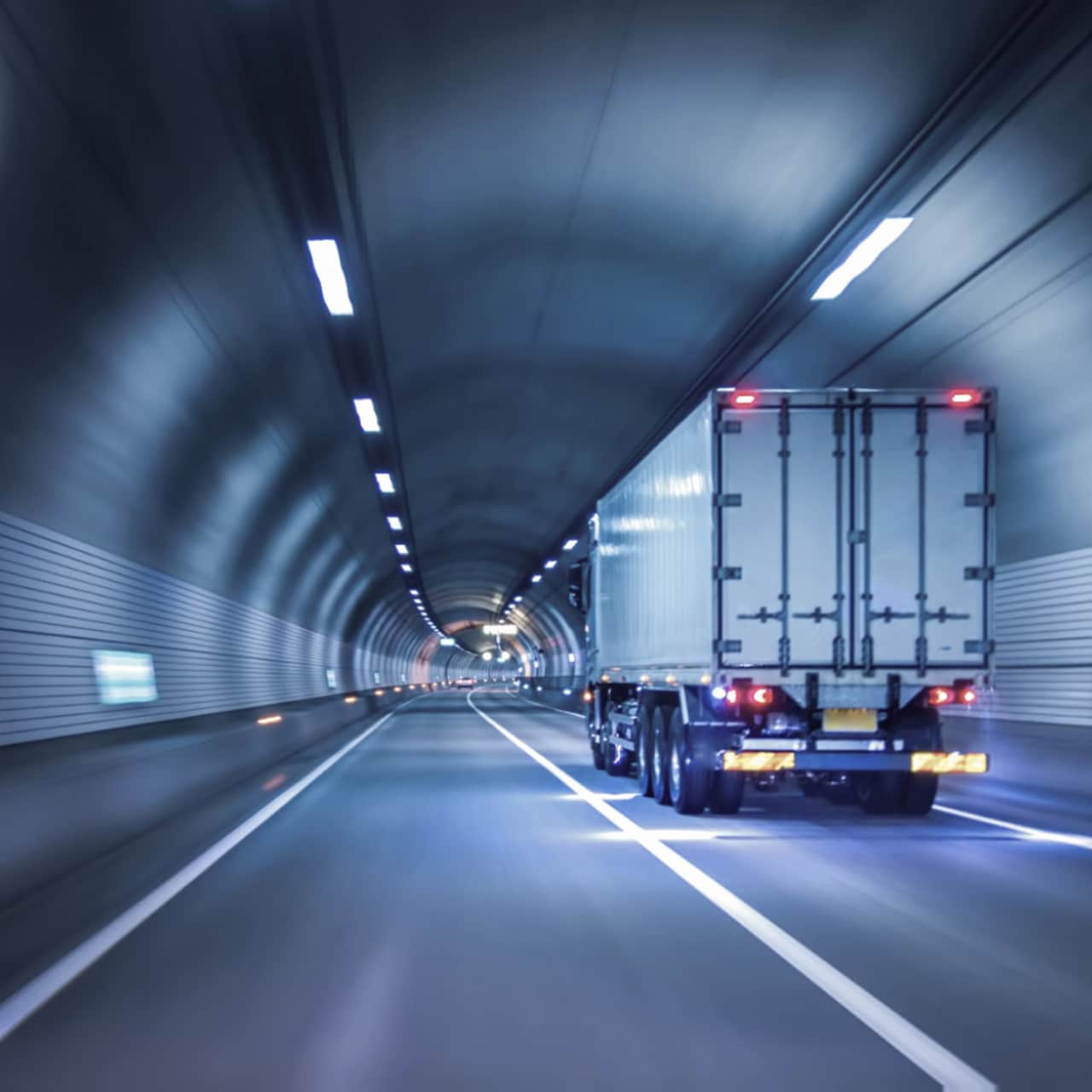 Truck driving through highway tunnel at night