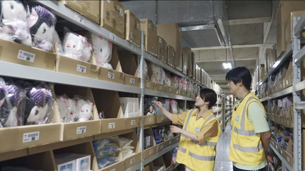 Supermarket staff arranging an aisle of soft toys