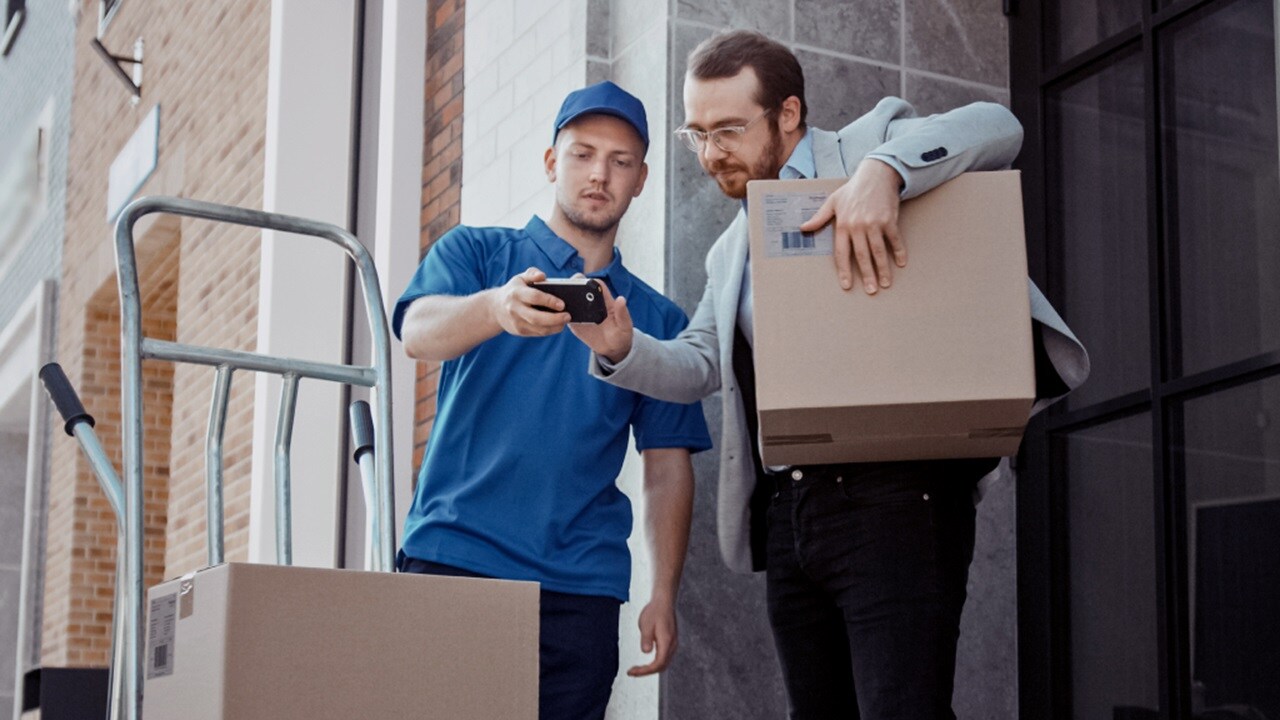 Male delivering shipment to another male