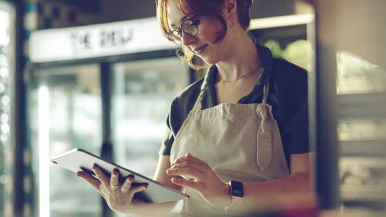 A woman wearing apron, using tablet