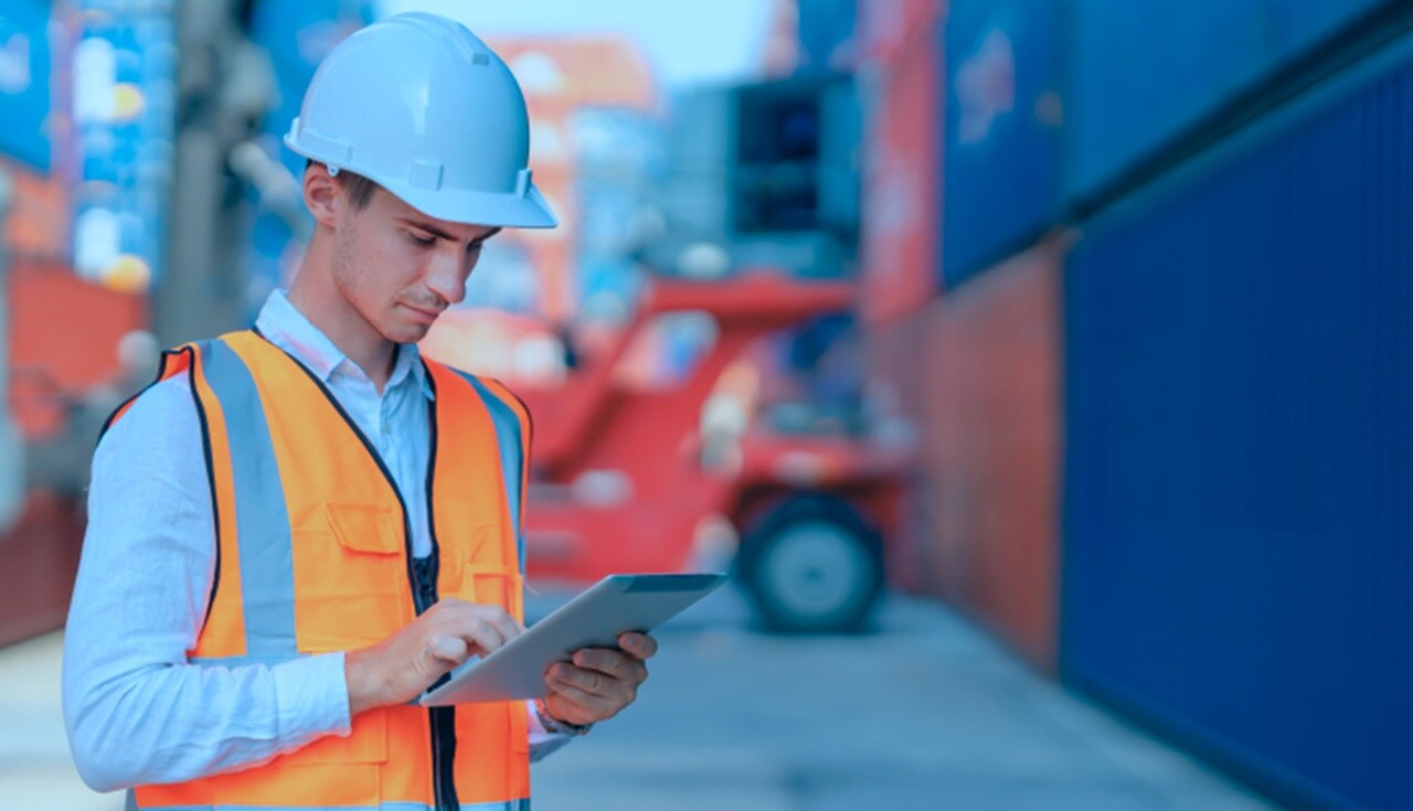 Male with protective gear working on a tablet 