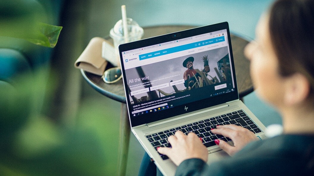 Woman typing on a computer and browsing Maersk website