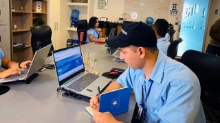 Maersk employee watching laptop and taking notes