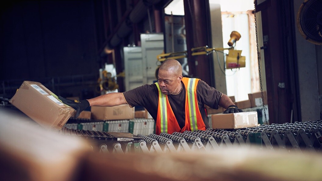 Man putting boxes on line.