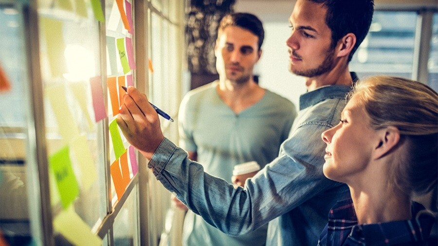 Colleagues brainstorming around whiteboard