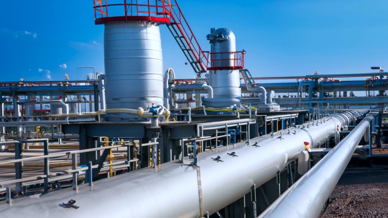 Pipes and valves interconnected in an oil refinery, showcasing industrial infrastructure and fluid control systems.