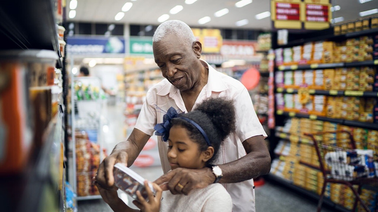 African grandfather and granddaughter buying FMCG in southern Africa market