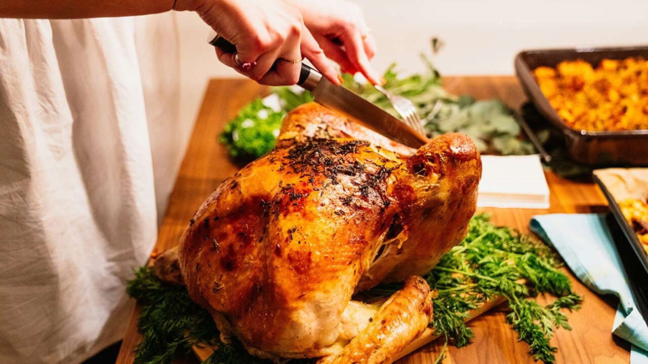 person about to slice the roasted chicken