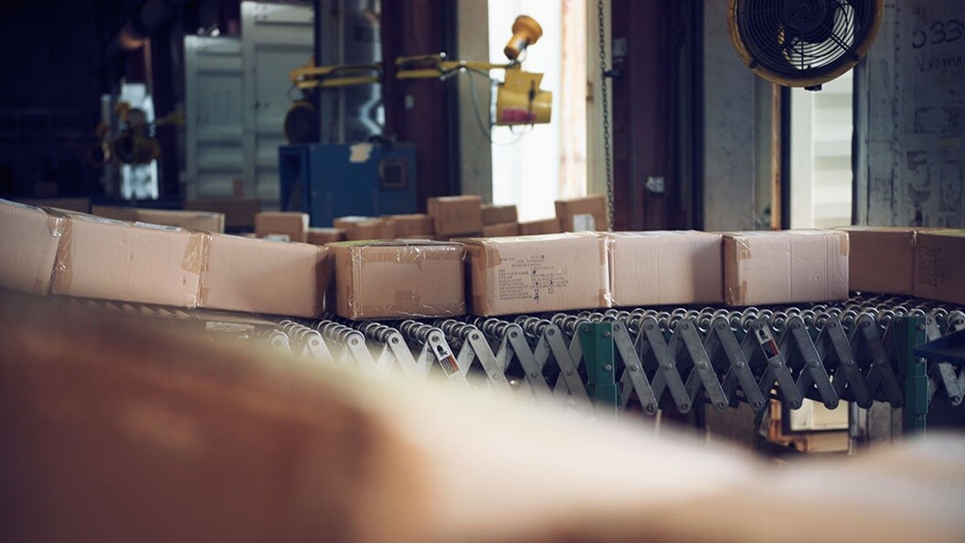 Boxes wait on a conveyor belt in a warehouse