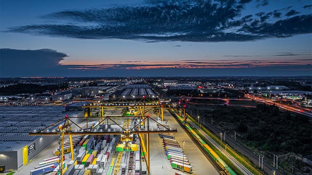 Busy shipping port with cranes and containers at dusk.