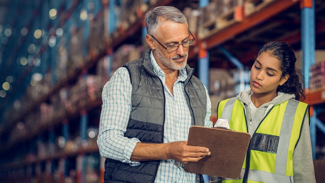 Two people looking at a clipboard
