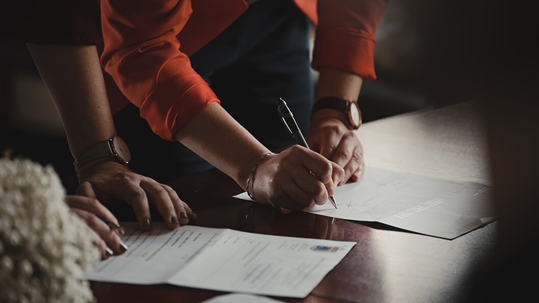Two people signing documents
