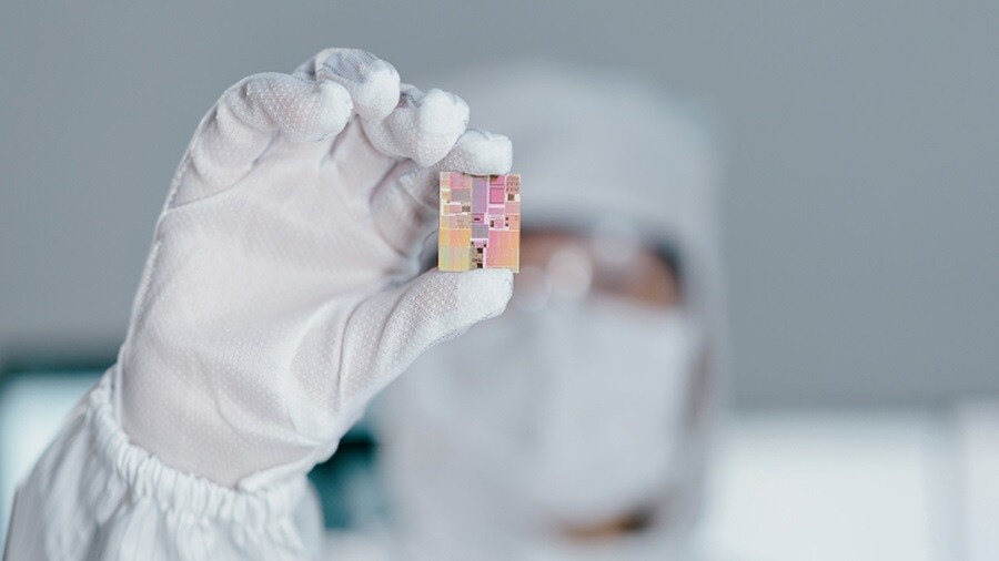 A person in a protective suit holding a chip