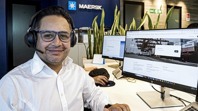 Maersk employee sitting at desk in front of computer 
