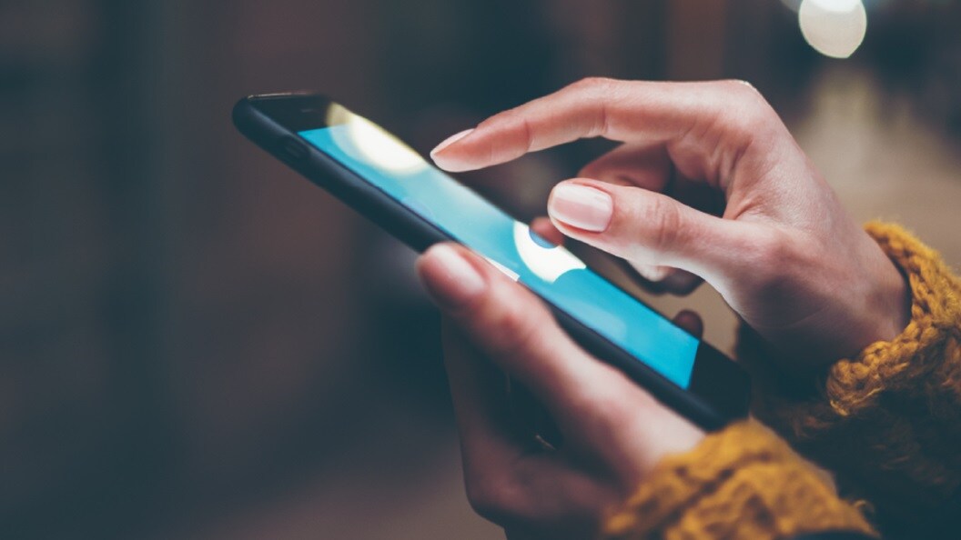 Close-up of a hand browsing customs insights on their mobile.