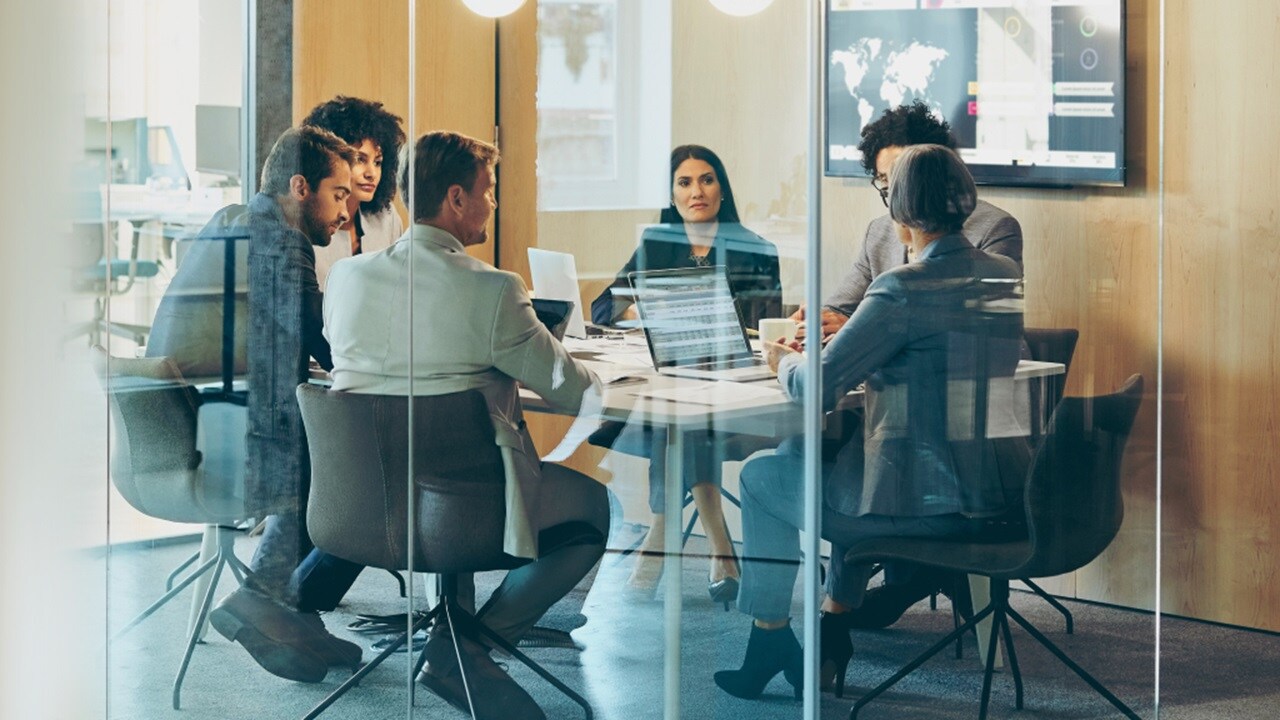 A group of employees discuss customs services in an office setting.