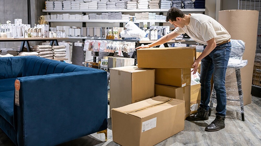Latin American delivery person delivering boxes at a furniture store