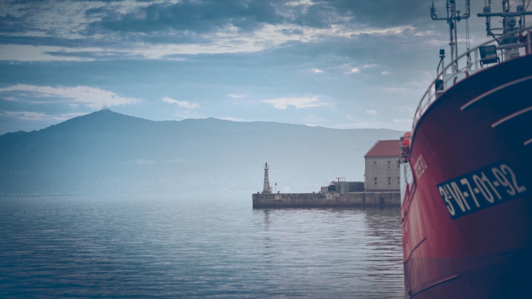 Ship docked with lighthouse in background