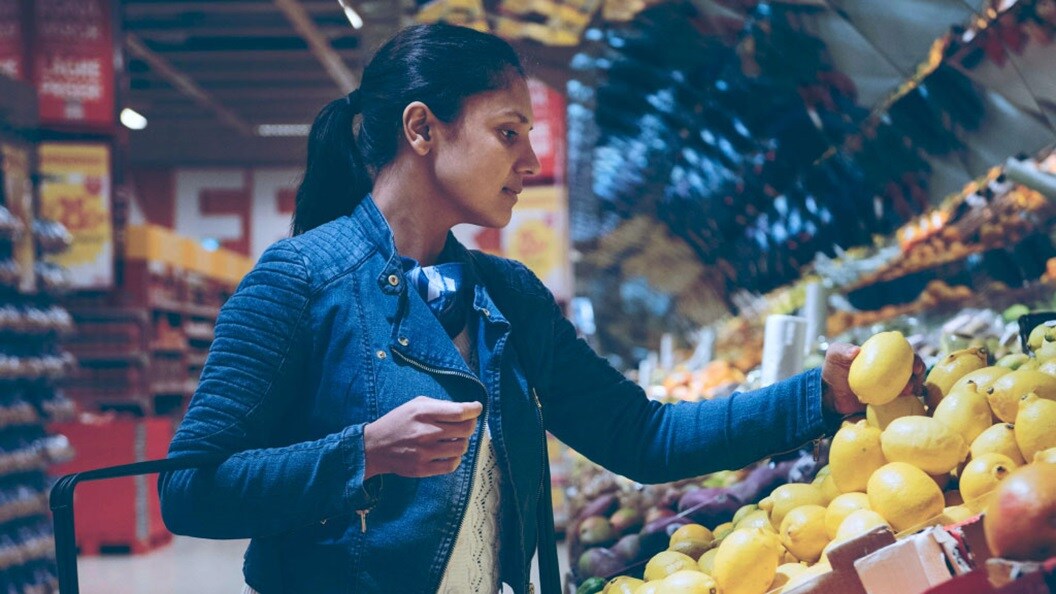 Female picking up fruits in a store