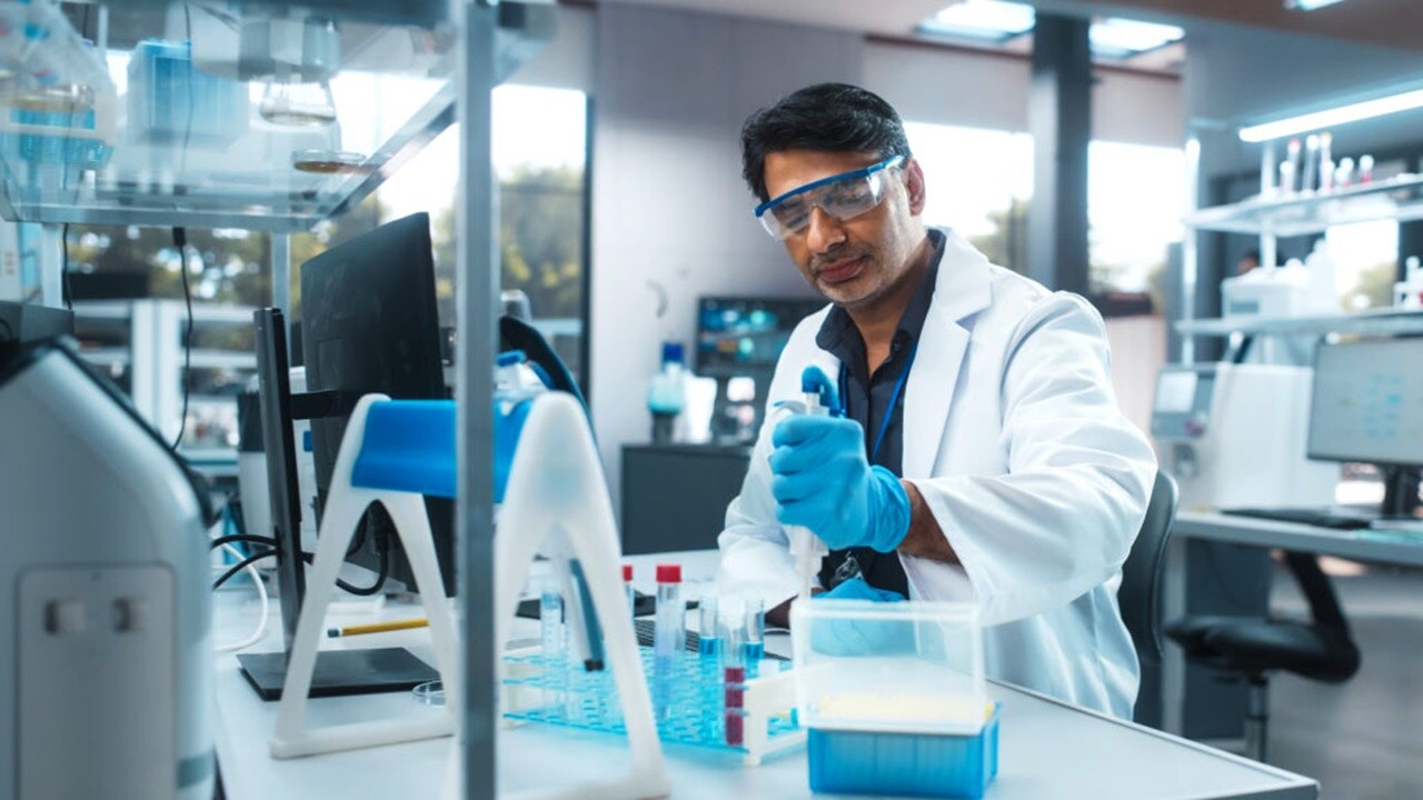 Scientist working with test tubes in a lab.