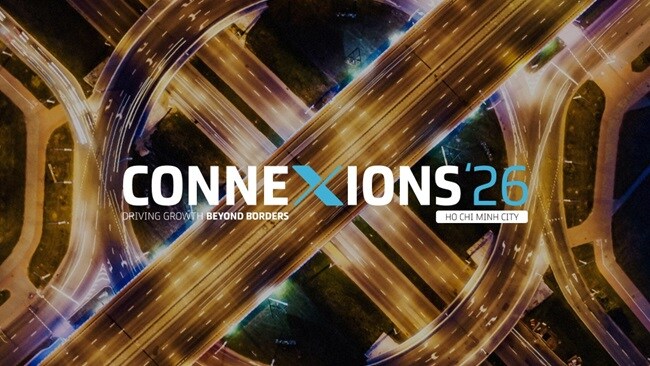 Aerial view of a highway intersection illuminated at night, showcasing the flow of traffic and surrounding city lights.