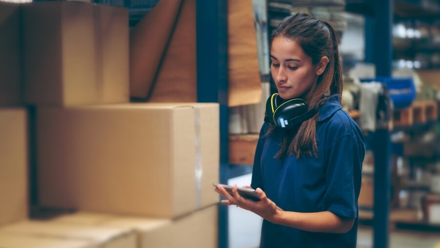 Woman checking shipping logs at a warehouse