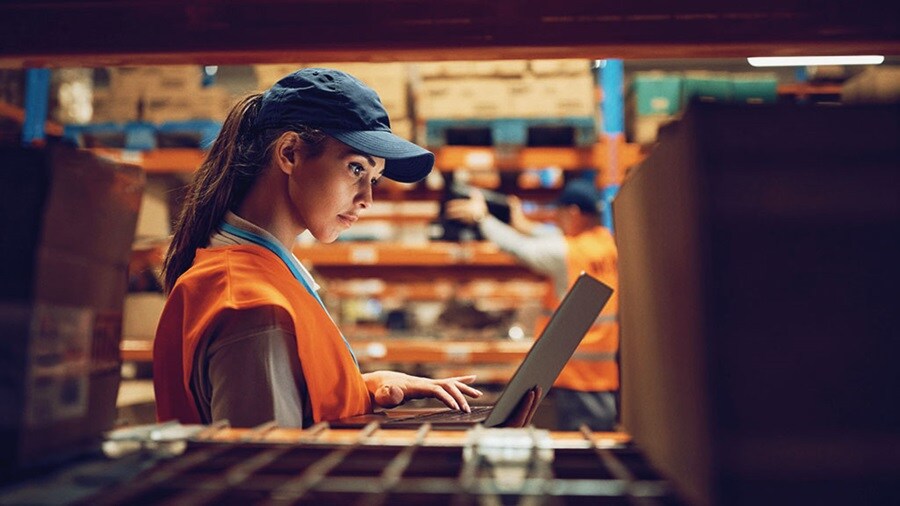 Woman with laptop at warehouse