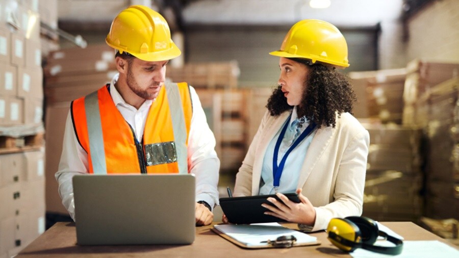 A male and a female conversing in a warehouse