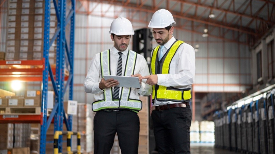 Two male working on a tablet in a warehouse