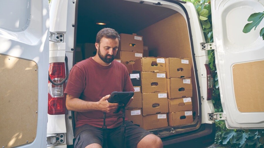 Male looking at a tablet in the back of the delivery truck