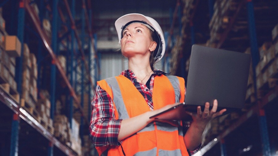 Female holding a laptop working in a warehouse