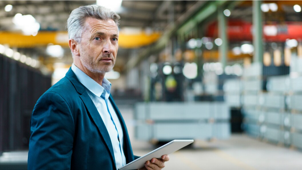 A man holding paper in hand and looking straight.