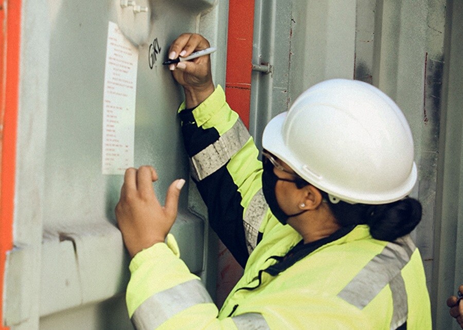 A.P. Moller Maersk employee at Pier 400, APM Terminals, signing container. 