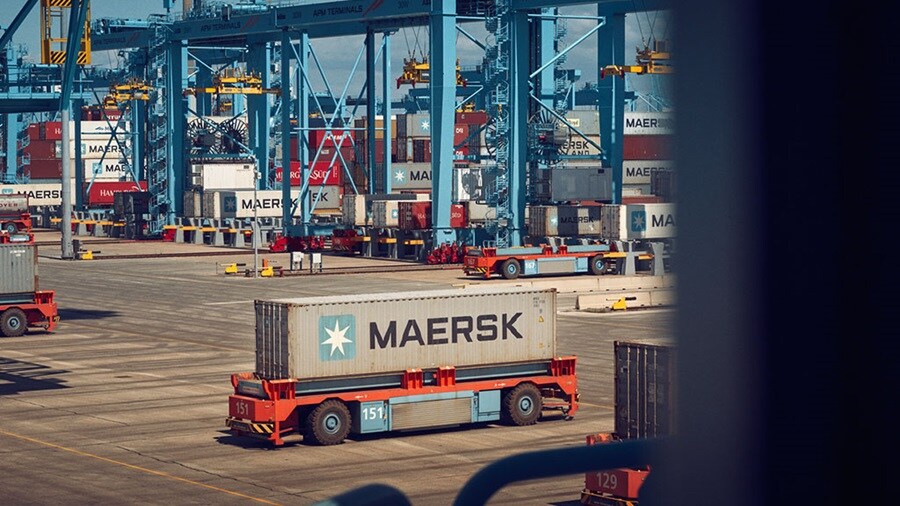 Two people in front of a Maersk container connecting Asia and Europe through the Middle Corridor.