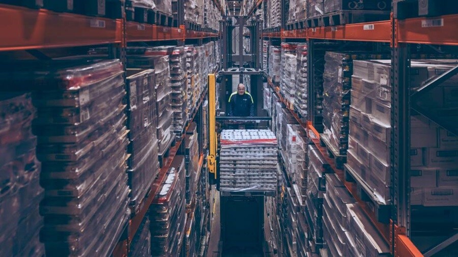 Male loading shipments using a forklift in the warehouse