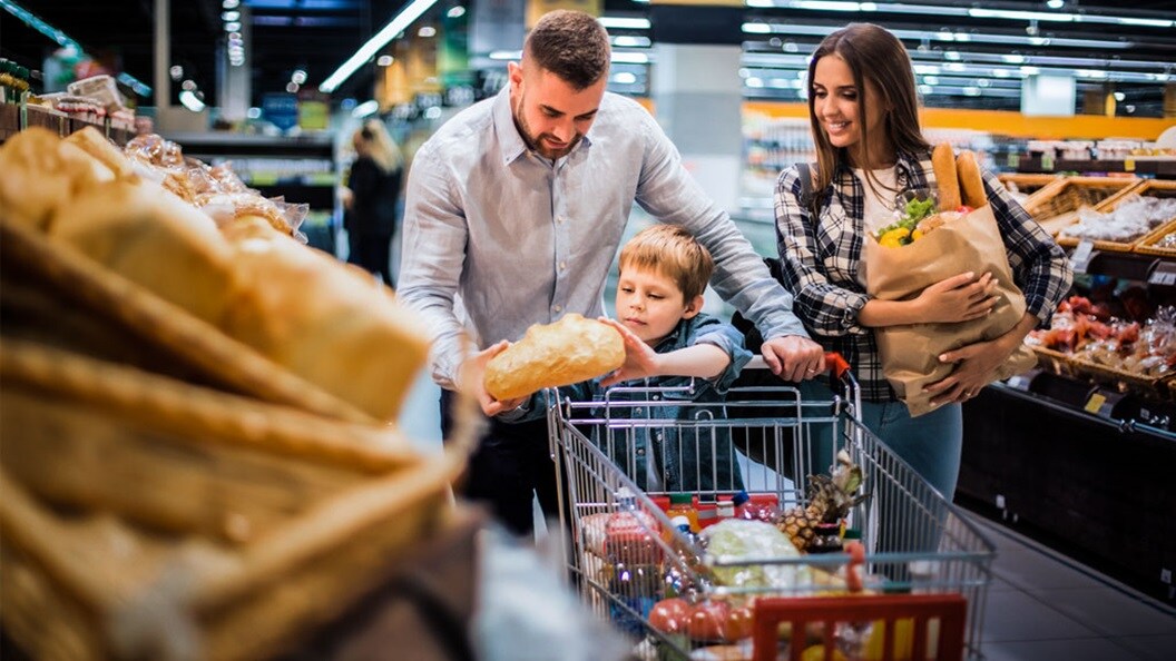 Familia joven y feliz haciendo la compra en un supermercado