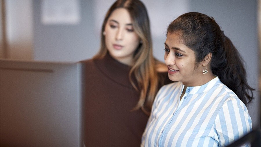 Two Maersk Customs Services consultants looking at a computer screen.