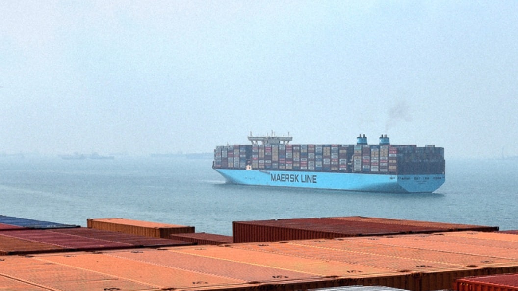 A large Maersk container ship navigates through calm waters, showcasing its colorful cargo containers stacked high