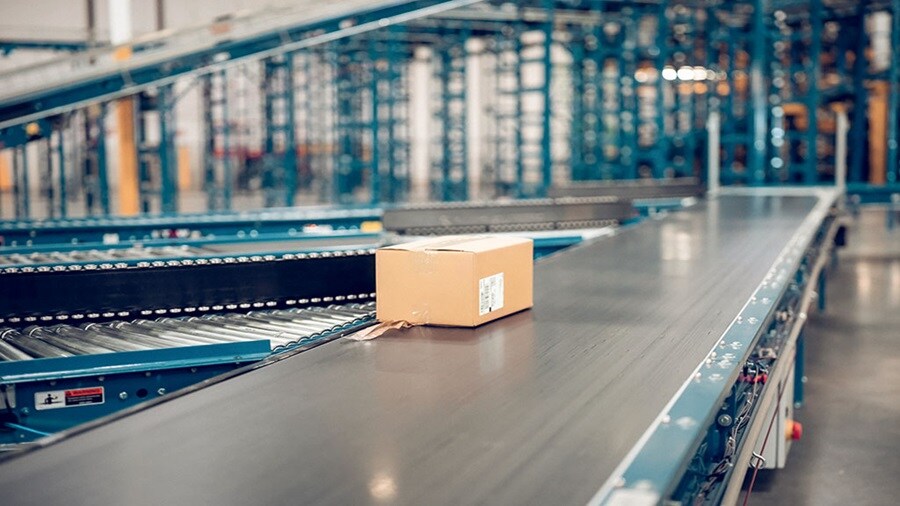 Ecommerce parcel on a conveyor belt in a warehouse.