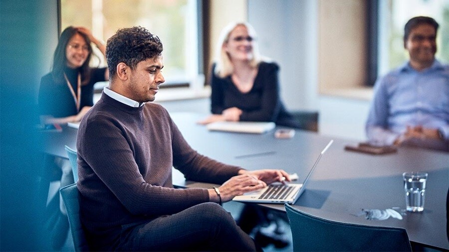 Four customs agent sitting around a table in a conference room.
