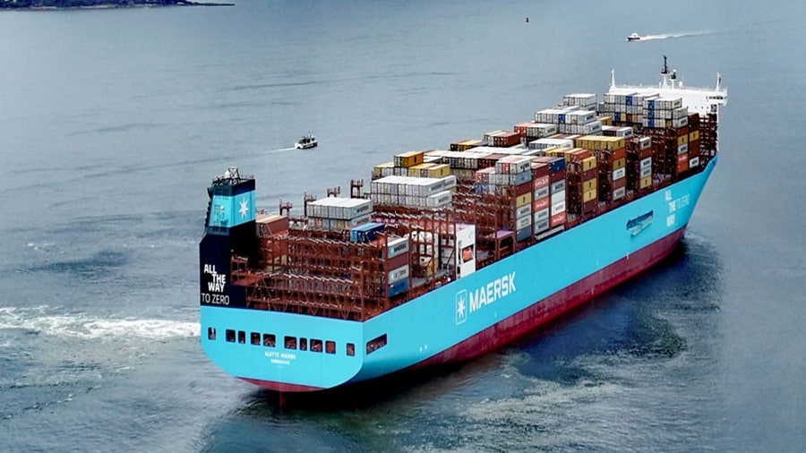 Aerial perspective of a container ship brimming with containers, showcasing its cargo against the ocean backdrop.