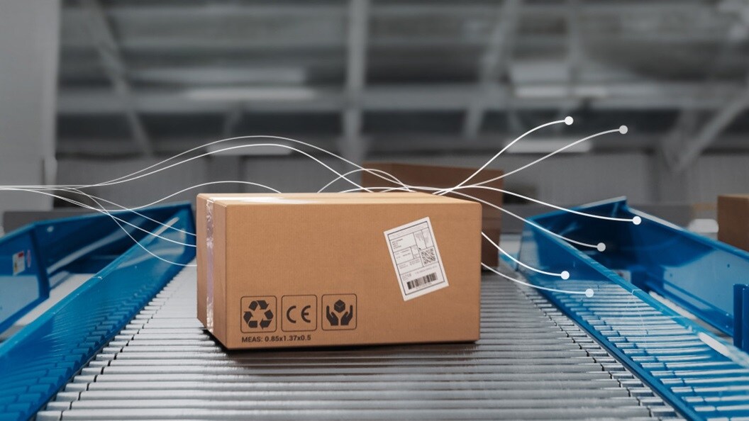 Cardboard package moving on a conveyor belt in a warehouse.