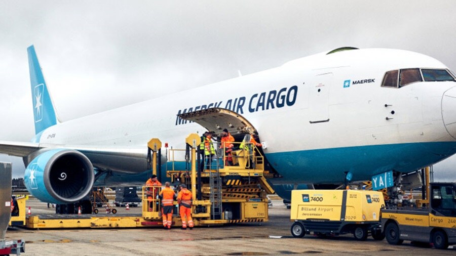 A large blue and white airplane parked on a runway under a clear sky.
