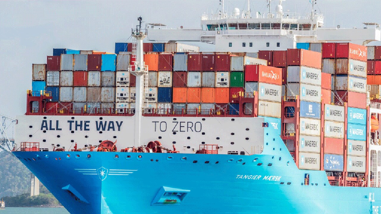 A massive container ship sailing on the ocean, showcasing a variety of stacked cargo containers.