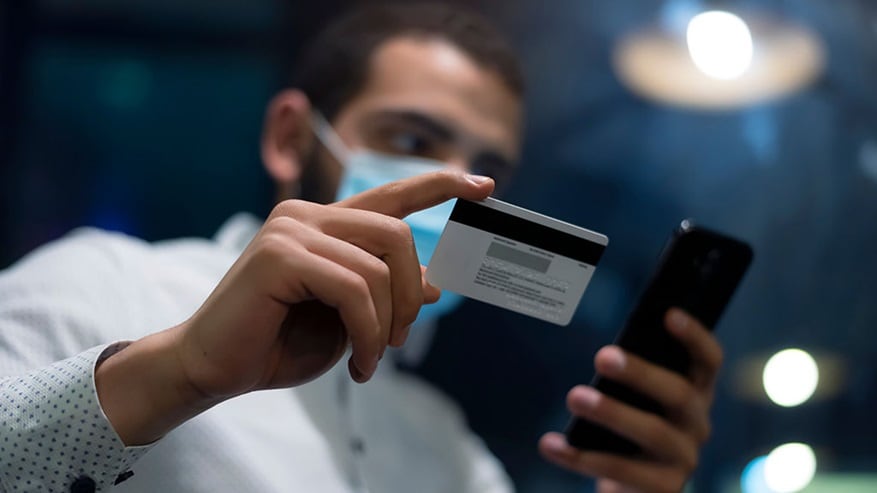 A guy is holding a credit/debit card