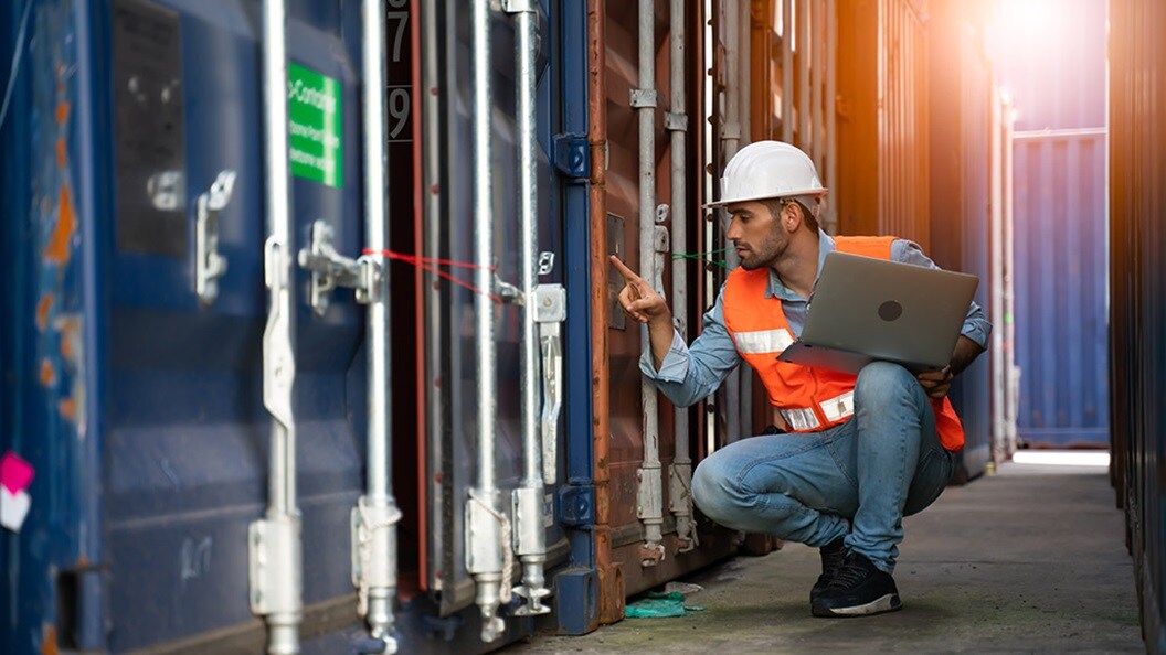 Employee with white hat and laptop in hand