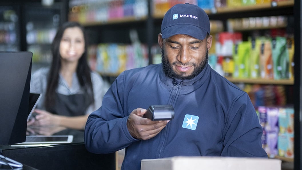 Repartidor de Maersk entregando pedidos en un local comercial