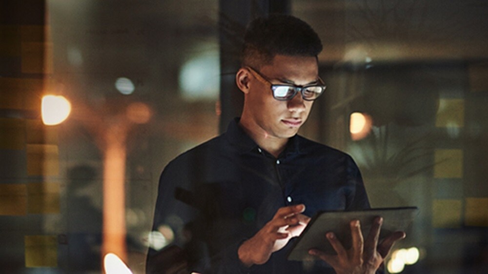 Ein junger Mann nutzt sein Tablet, um API-Lösungen zu betrachten.